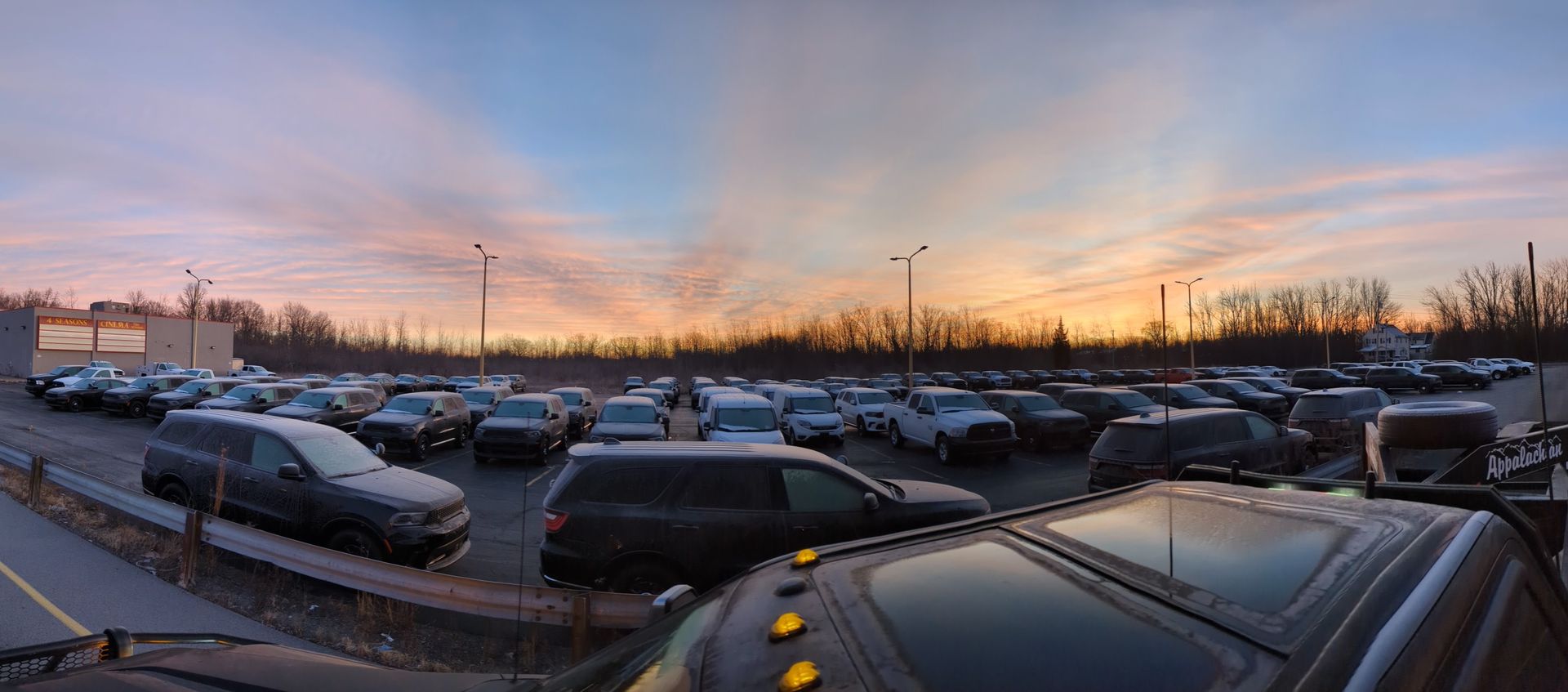 Rows of fleet vehicles parked in a lot at sunset