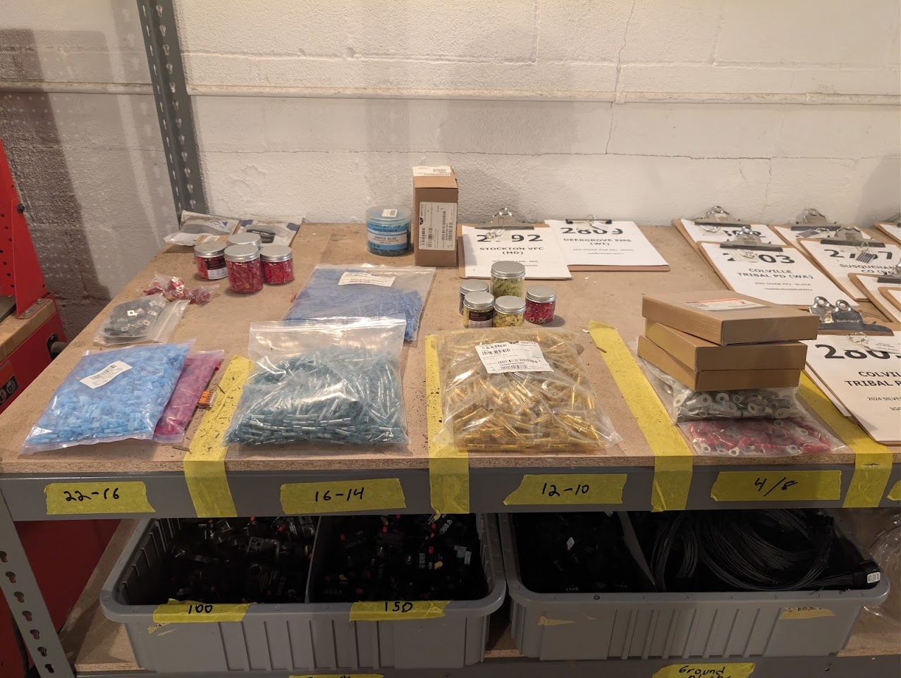 Upfit parts laid out on a pallet in labeled bags with a printed kit sheet